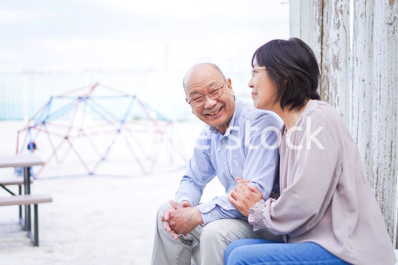 リゾート地で仲良く会話をする高齢の夫婦