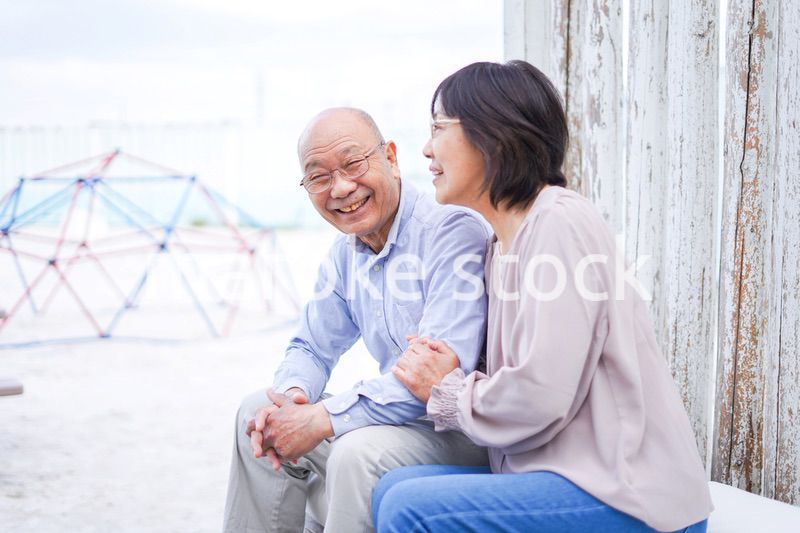 リゾート地で仲良く会話をする高齢の夫婦