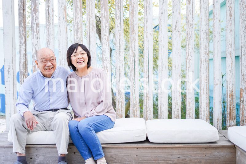 リゾート地で仲良く会話をする高齢の夫婦