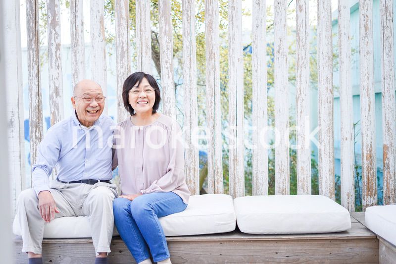 リゾート地で仲良く会話をする高齢の夫婦