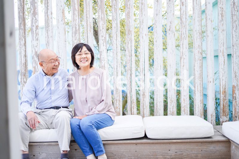 リゾート地で仲良く会話をする高齢の夫婦