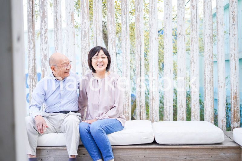 リゾート地で仲良く会話をする高齢の夫婦