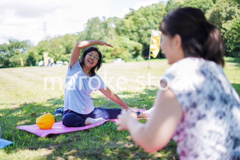 野外でヨガをする高齢者