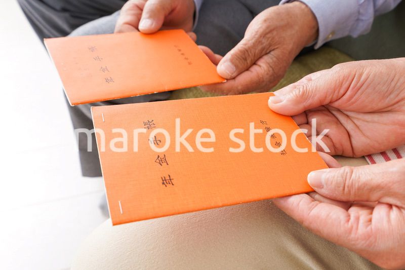 年金手帳を持つ高齢の夫婦