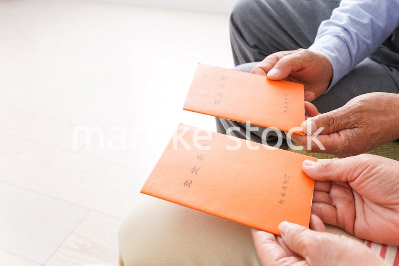 年金手帳を持つ高齢の夫婦