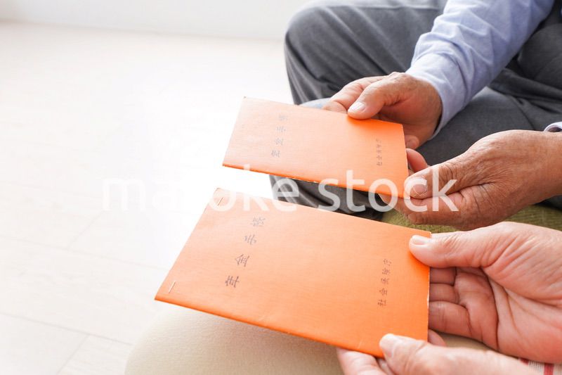 年金手帳を持つ高齢の夫婦