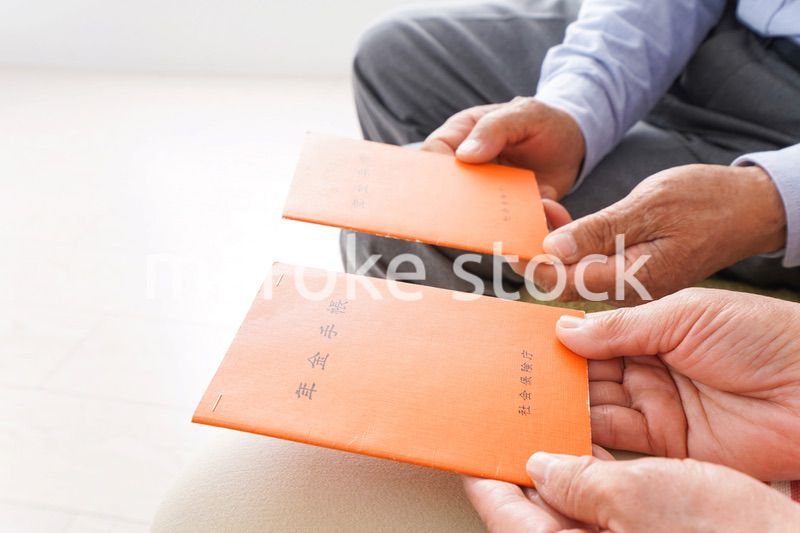 年金手帳を持つ高齢の夫婦