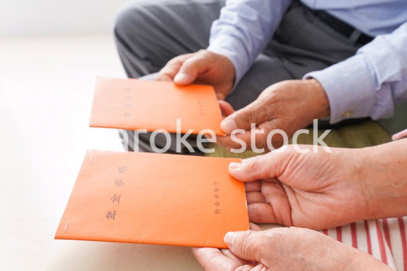 年金手帳を持つ高齢の夫婦