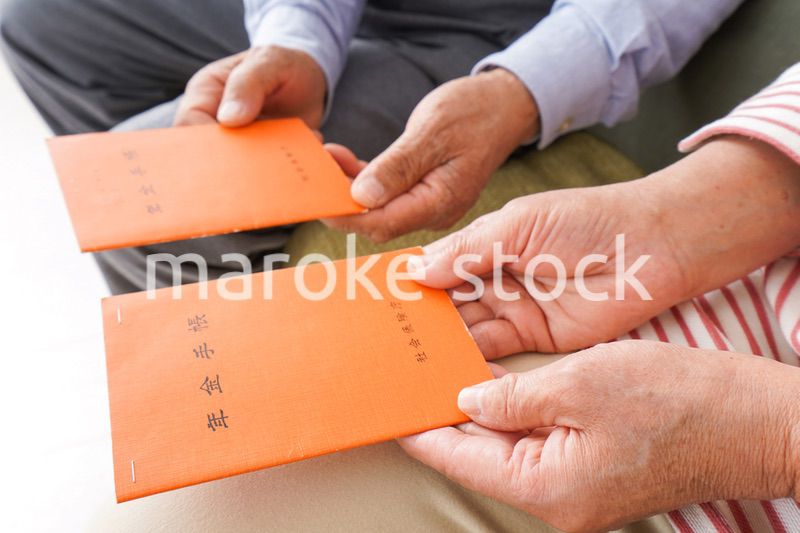 年金手帳を持つ高齢の夫婦