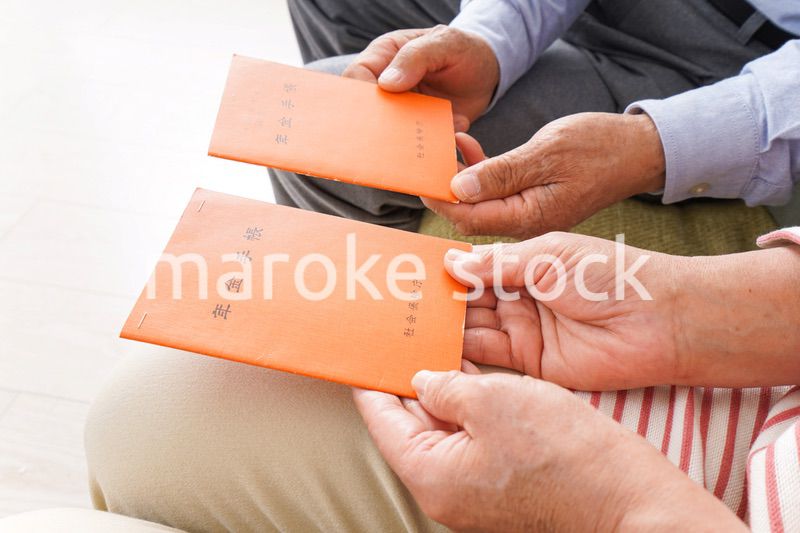 年金手帳を持つ高齢の夫婦