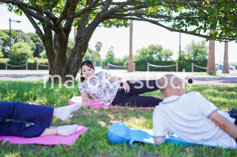 野外でヨガをする高齢者