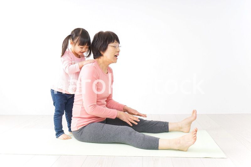 体操をするシニア女性と孫