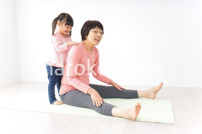 体操をするシニア女性と孫