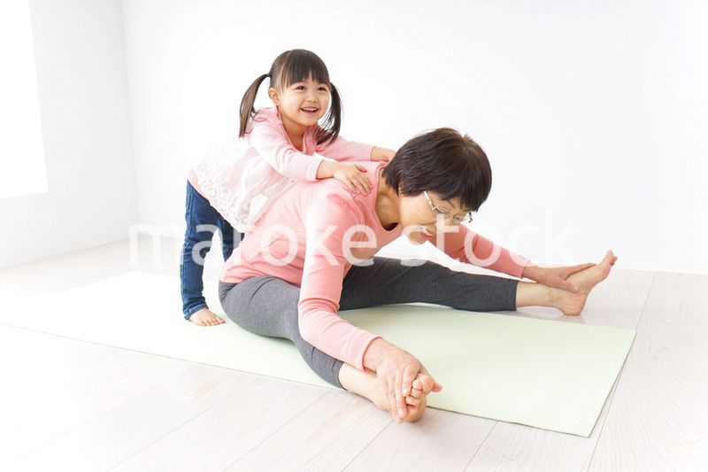 体操をするシニア女性と孫