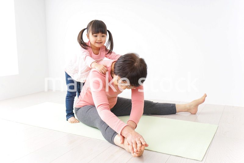 体操をするシニア女性と孫