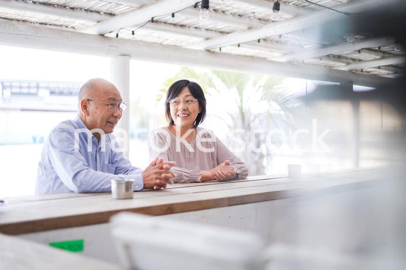 バーカウンターに座るシニアの夫婦