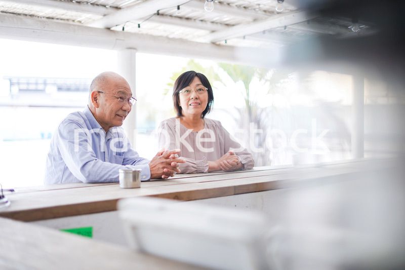 バーカウンターに座るシニアの夫婦