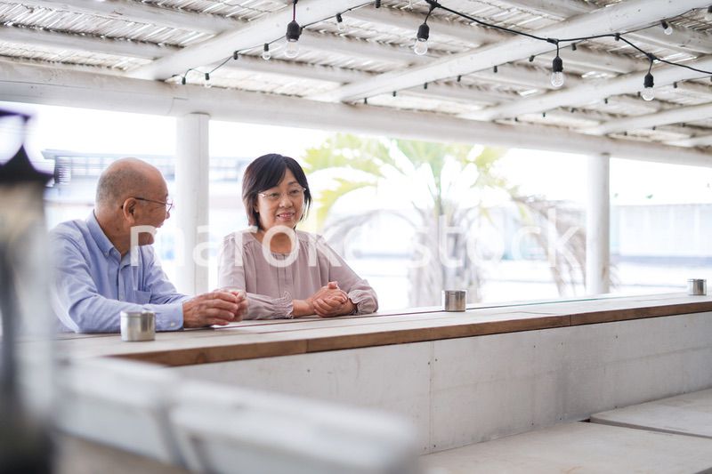 バーカウンターに座るシニアの夫婦