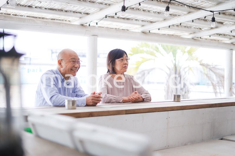 バーカウンターに座るシニアの夫婦