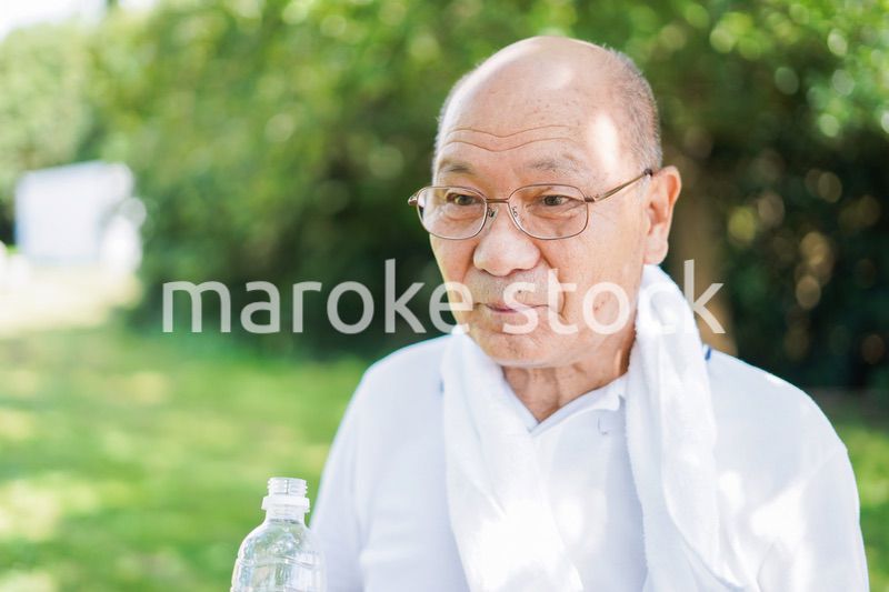 野外で水分補給をする高齢の男性