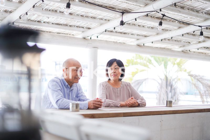 バーカウンターに座るシニアの夫婦