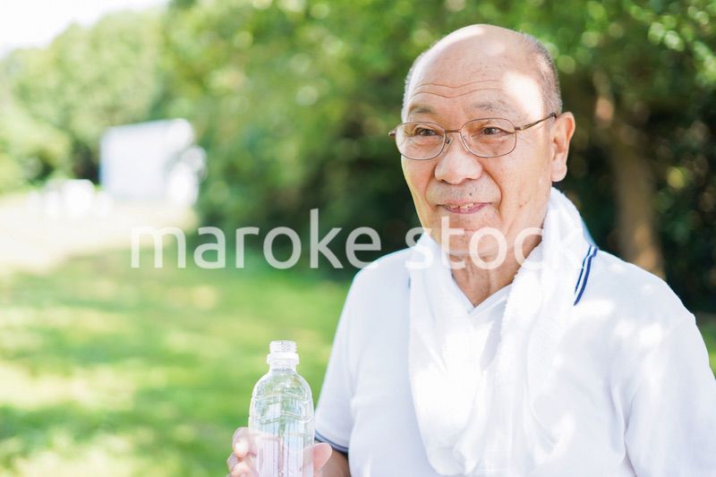 野外で水分補給をする高齢の男性