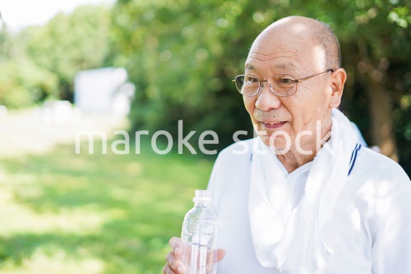 野外で水分補給をする高齢の男性