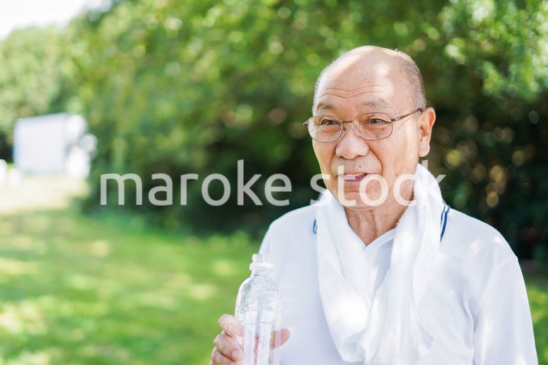 野外で水分補給をする高齢の男性