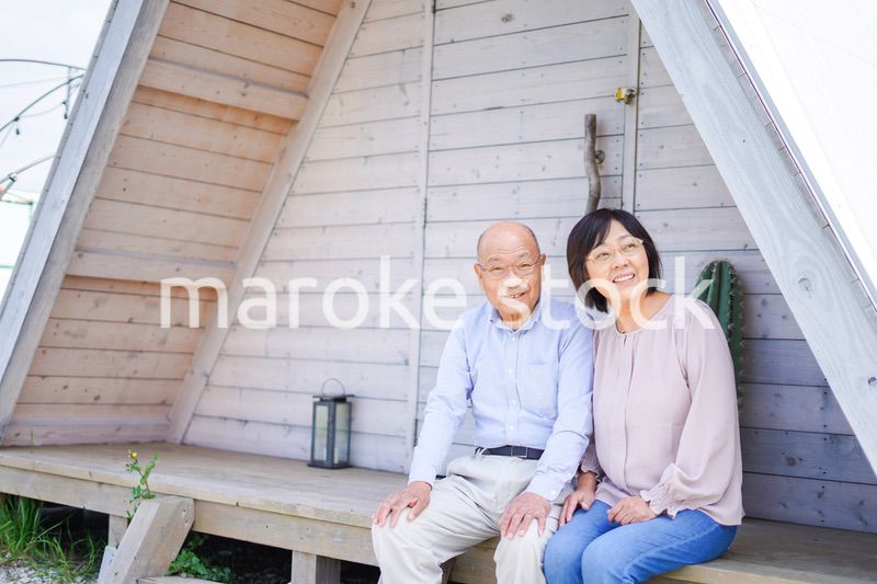 別荘の前に座るシニアの夫婦
