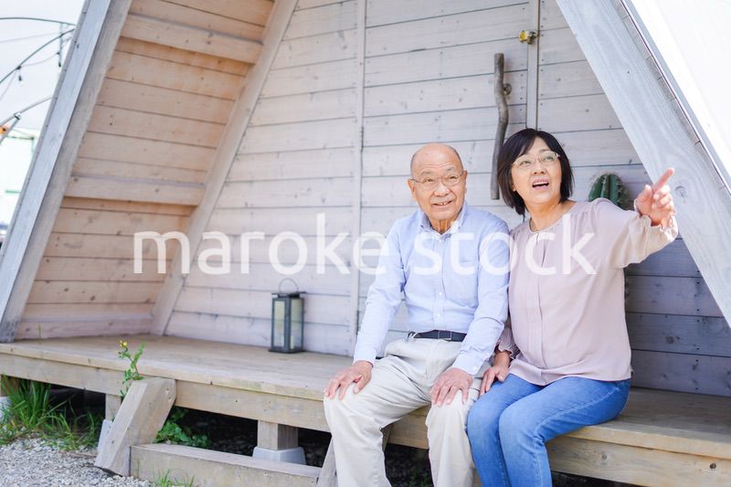 別荘の前に座るシニアの夫婦