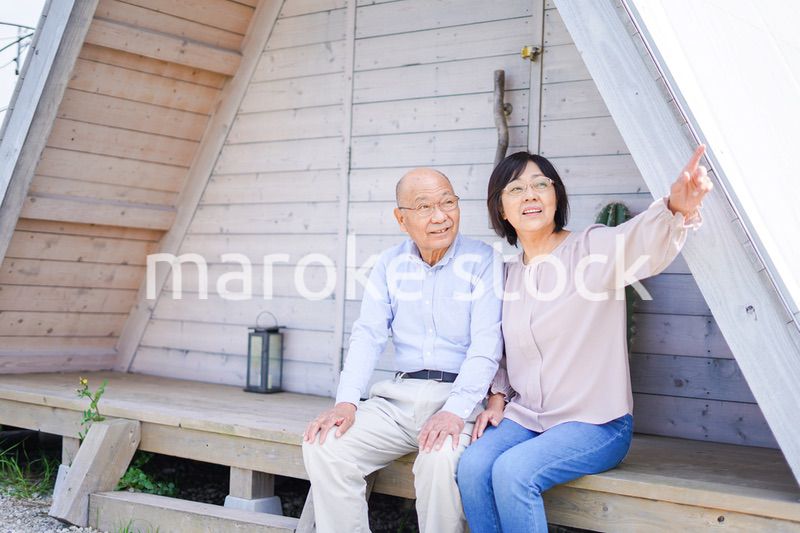 別荘の前に座るシニアの夫婦