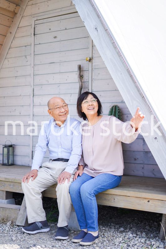 別荘の前に座るシニアの夫婦