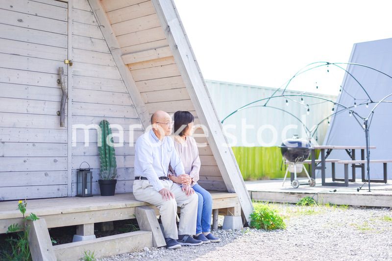 別荘の前に座るシニアの夫婦