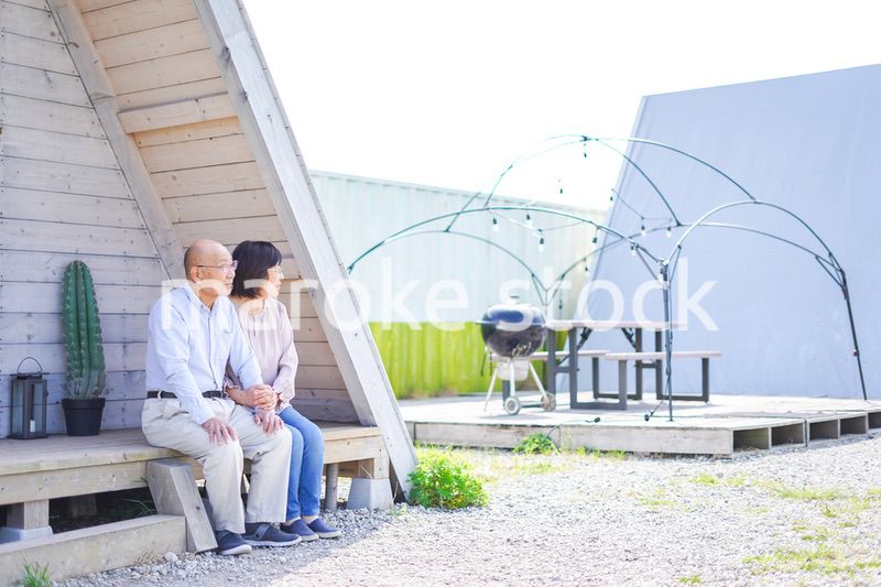 別荘の前に座るシニアの夫婦