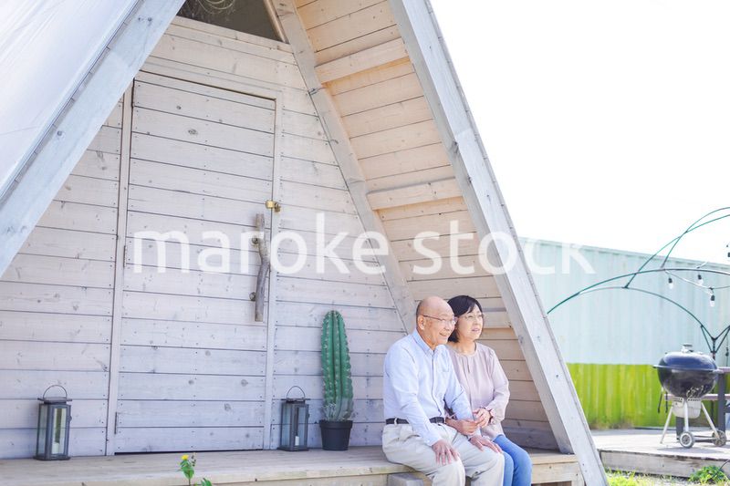 別荘の前に座るシニアの夫婦