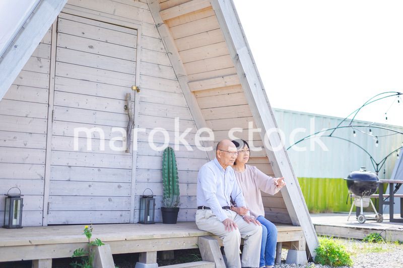 別荘の前に座るシニアの夫婦