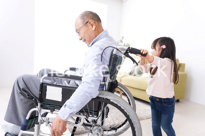 車椅子に乗る高齢男性と女の子