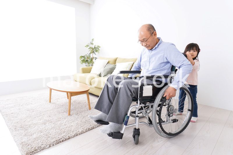 車椅子に乗る高齢男性と女の子