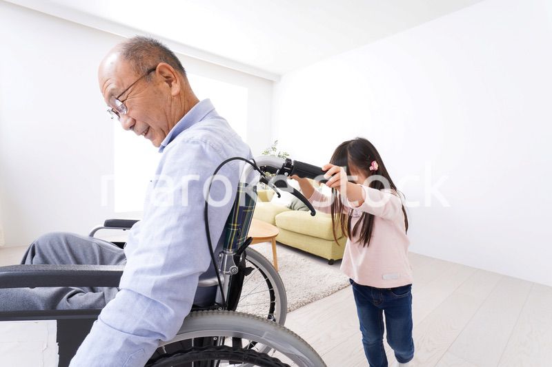 車椅子に乗る高齢男性と女の子