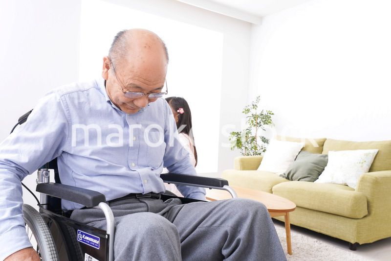 車椅子に乗る高齢男性と女の子