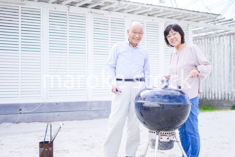 屋外でバーベキューをするアクティブシニア