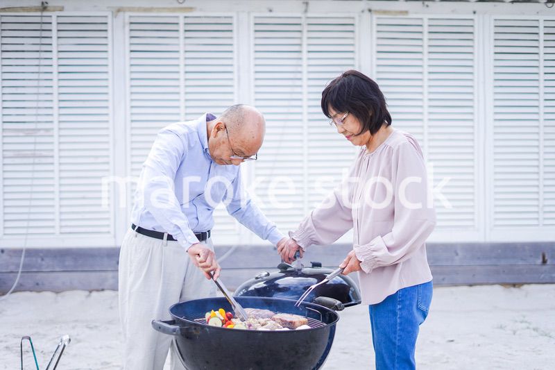 屋外でバーベキューをするアクティブシニア