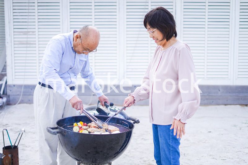 屋外でバーベキューをするアクティブシニア