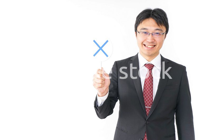 バツ印を示すビジネスマン