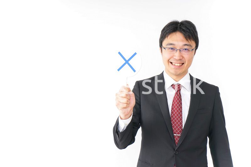 バツ印を示すビジネスマン