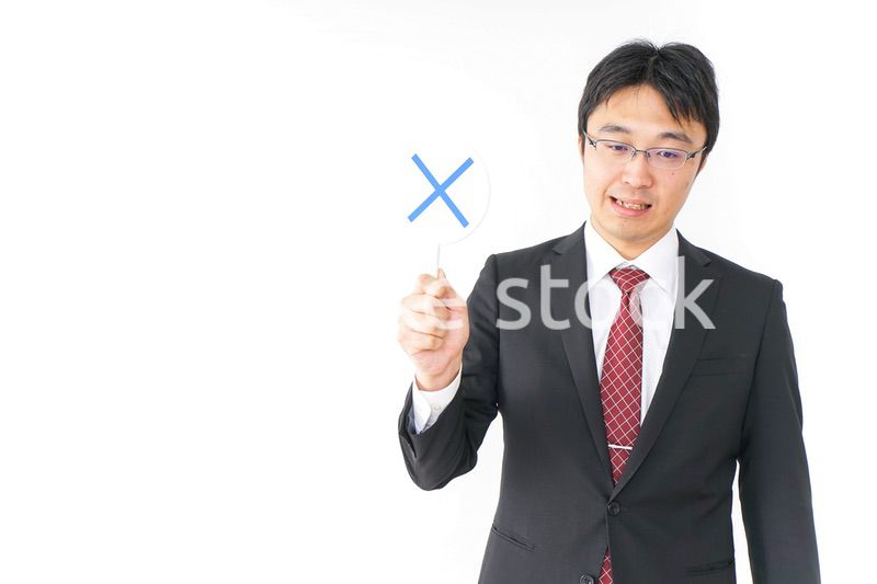 バツ印を示すビジネスマン