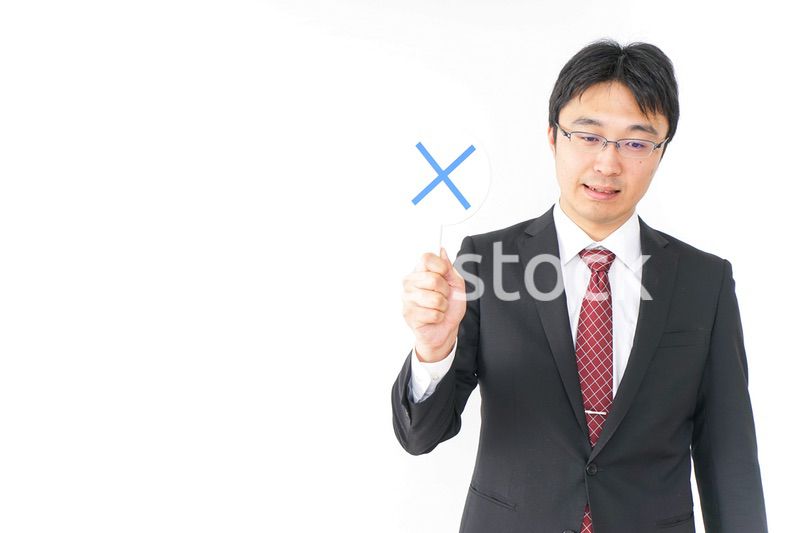 バツ印を示すビジネスマン