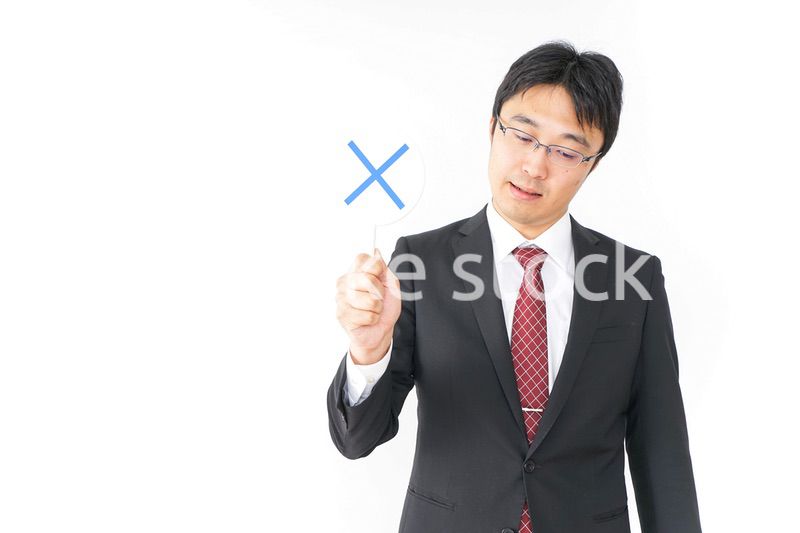 バツ印を示すビジネスマン