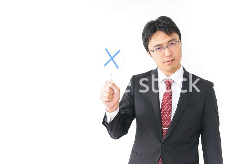 バツ印を示すビジネスマン