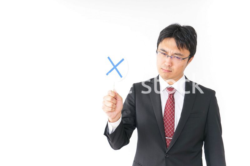 バツ印を示すビジネスマン